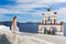 Beautiful young woman and bells on Santorini island