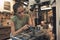 A beautiful young woman bicycle mechanic is repairing a bike in the workshop