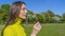 Beautiful young woman blowing a dandelion. Girl with dandelion in hand. Allergic to pollen of flowers. Spring allergy.