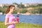 Beautiful young woman with bottle of water resting after training outdoors