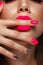 Beautiful young woman with bright makeup and neon pink nails. Beauty face. Photo taken in the studio