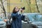 Beautiful young woman with camera in city. Tourist girl traveling and photographing, spring city street background