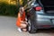 Beautiful young woman changing damaged wheel and fixing it