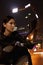 Beautiful young woman checking herself in the side mirror of a motorcycle, outdoors at night in Beijing