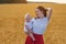 Beautiful young woman with child on background of yellow fields. Mother and child at sunset outdoors