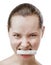 Beautiful Young Woman with Clean Fresh Skin Holds a tube of cosmetic product in your teeth. Predatory facial expression.