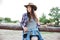 Beautiful young woman cowgirl in hat and checkered shirt