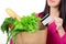 Beautiful young woman with credit card holding paper bag with groceries. Isolated. Shopping and groceries concept.