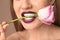 Beautiful young woman with dark lipstick and flower in mouth, closeup