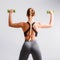 Beautiful young woman doing exercises with dumbbells. Photo athletic woman with perfect body on white background