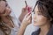 Beautiful young woman doing makeup at a professional makeup artist.