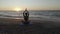 Beautiful Young Woman Doing Sitting Yoga on the Beach while Watching the Sunset.