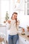 Beautiful young woman drink tea at the festive kitchen.