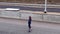 A beautiful young woman drives alone on the highway on the hoverboard towards sunset