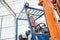 Beautiful young woman driving forklift in greenhouse