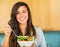 Beautiful young woman eating a bowl of healthy organic salad