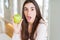 Beautiful young woman eating healthy green apple fruit scared in shock with a surprise face, afraid and excited with fear