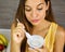 Beautiful young woman eating light Greek yogurt at home. Close up from above. Healthy concept