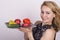 Beautiful young woman eating an vegetables. holding a plate with vegetables, red pepper, tomato, cucumber. healthy food