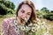 Beautiful young woman enjoying eating camomile field flowers for fun