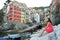 Beautiful young woman enjoying the view of Riomaggiore in the UNESCO World Heritage Site Cinque Terre, Five Lands, Italy