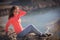 Beautiful young woman enjoys the beauty Valley along the hiking trail posing on the rock on sunny day in Altai