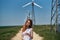 Beautiful young woman in a field near a windmill, summer, sun