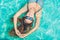 Beautiful young woman floating in pool relaxing Top view. Holiday concept