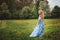 Beautiful young woman in floral blue maxi skirt walking in spring