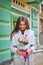 Beautiful young woman with flowers bouquet at city street. Spring portrait of pretty female