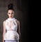 Beautiful young woman in a futuristic manner. White dress, hair is collected, make-up