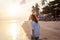 Beautiful young woman girl with flying curly hair on the background of a tropical beach at sunset, beauty, freedom, pleasure, joy