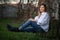 Beautiful young woman or girl lying on a grass and a fence. Trees in the background, shot on the sunset.