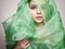 Beautiful young woman in green silk veil. colorful make-up girl