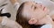 Beautiful young woman with hairdresser washing head at hair salon