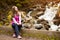 Beautiful young woman happy near forest waterfall