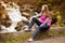 Beautiful young woman happy near forest waterfall