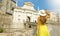 Beautiful young woman with hat climbs towards Porta San Giacomo gate in Bergamo Upper City on sunny day. Summer holidays in Italy