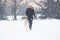 Beautiful young woman and her dog akita walking in park on snow