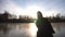 Beautiful young woman holded male hand and start sliding on figure skate at frozen river. Girl skating on ice with