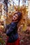 Beautiful young woman holding a bunch of autumn leaves, romantic dreaming mood, fall walking, relax time in the forest