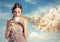 Beautiful young woman holding a cup of tea over a sky background