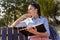 Beautiful young woman holding open book and reading on bench