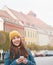 Beautiful young woman holding a smartphone on Wroclaw street