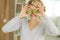 Beautiful young woman holding two kiwis on eyes