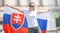 Beautiful young woman holds a flag of Slovakia oudoors on a sunny day, wearing sunglasses