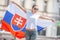 Beautiful young woman holds a flag of Slovakia oudoors on a sunny day, wearing sunglasses