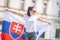 Beautiful young woman holds a flag of Slovakia oudoors on a sunny day, wearing sunglasses