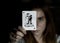 Beautiful young woman holds a playing card joker