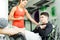 Beautiful young woman instructing a young man in the gym